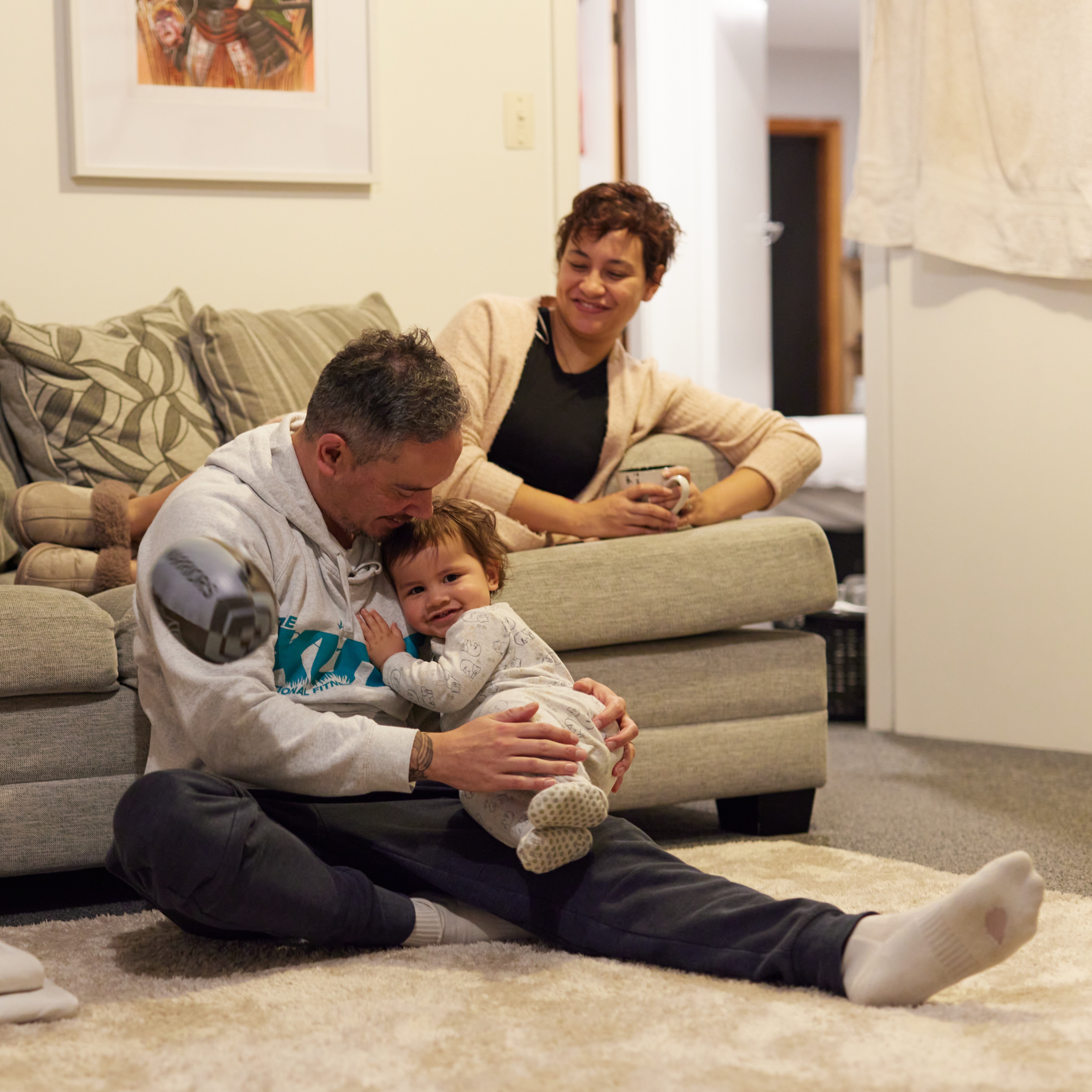 a man sitting on the floor holding a baby